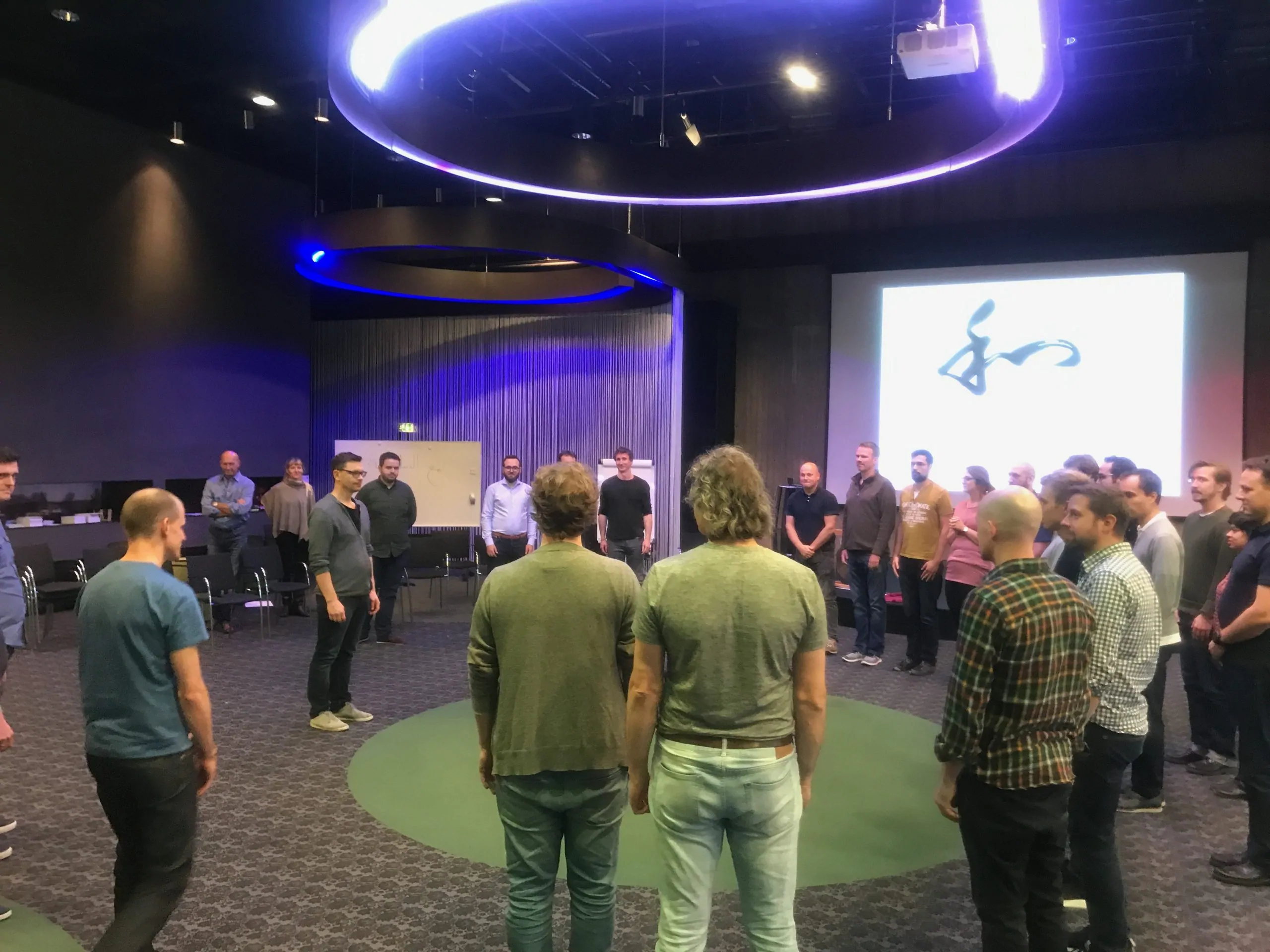 IMG_4429 Circle of people stood in a room facing each other and collaborating as a group